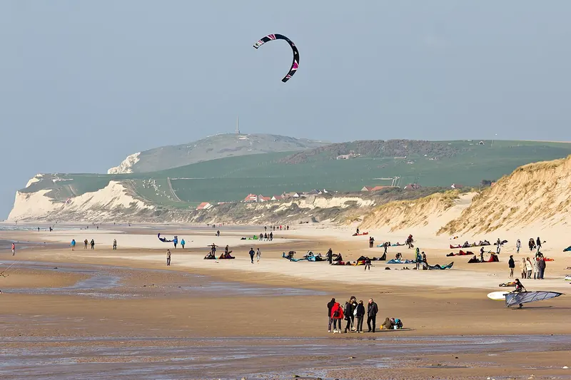 Kitesurfer op het strand van Wissant met kaap Blanc-Nez op de achtergrond