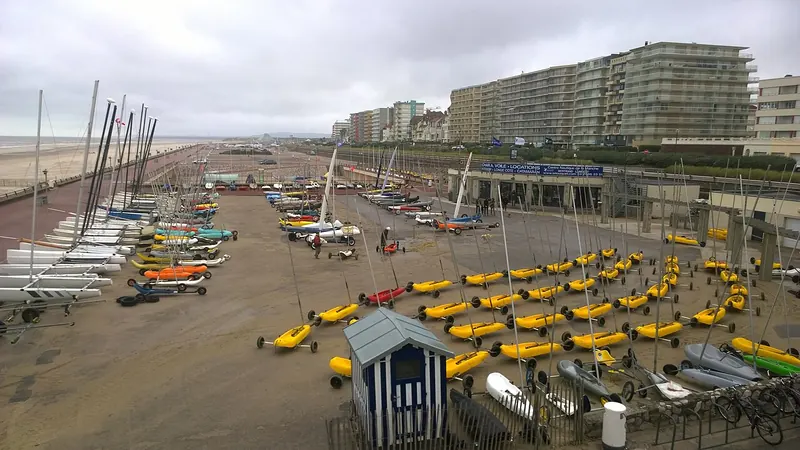 Strandzeilers opgesteld aan de zeedijk van Le Touquet onder een grijze hemel